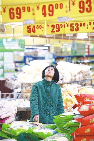 　　2014年1月9日，江西九江，消费者在一家超市查看大米价格牌。 图/CFP